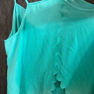 No Boundaries woman’s teal tank with cutout design at the bottom and “X” back.